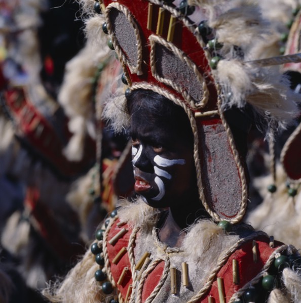 PHILIPPINES, Luzon, Manila, Young girl in costume at Ati-Atihan festival with a black painted face