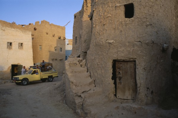 EGYPT, Western Desert, Siwa Oasis, Pick-up truck loaded with people and goods in street below Shali
