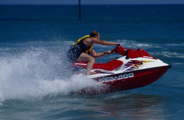 20002911 SPORT Watersports Jet Ski Man riding a jet ski on the sea at Littlehampton in West Sussex  England.  Viewed from the side.