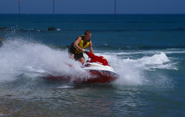 20002912 SPORT Watersports Jet Ski Man riding a jet ski on the sea at Littlehampton in West Sussex  England.
