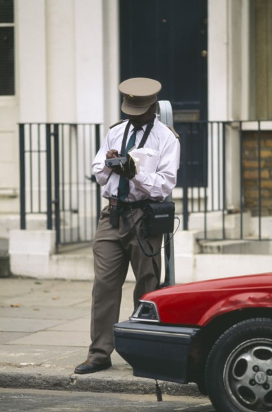 ENGLAND, London, Illegally parked car being giver parking ticket by traffic warden