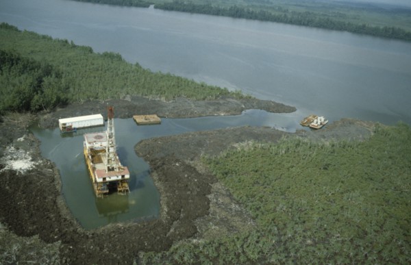 NIGERIA, Rivers State, Bonny, Oil rig in the swamp beside a river