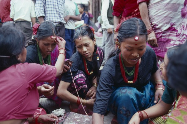 NEPAL, Religion, Young women receiving Tikas a mark of blessing on their forehead