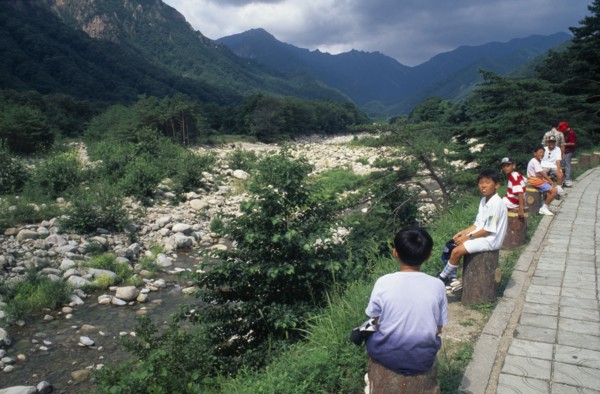 SOUTH KOREA, Soraksan Nat. Park, Sorak Mountains, Ssang-Chon River.  Children sitting beside almost