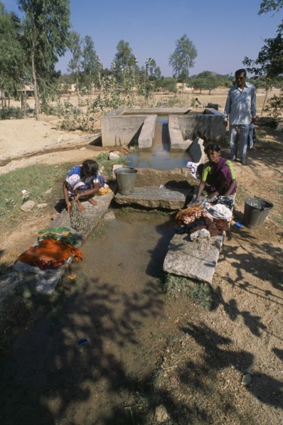 INDIA, Andhra Pradesh, Anantapur, Women washing clothes in irrigation outlet