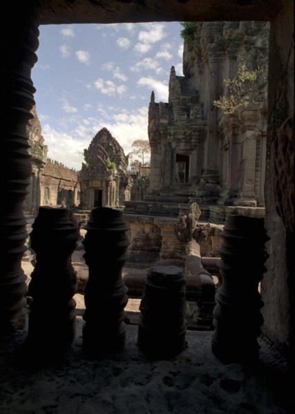 CAMBODIA, Angkor, View through archway over pink sandstone ruins of Banteay Srei or The Citadel of