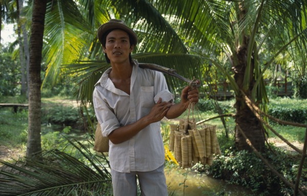 VIETNAM, Giang Province, Roadside vendor selling sticky rice wrapped in banana leaves.