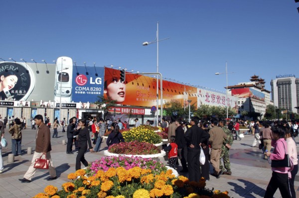 CHINA, Beijing, Busy commercial shopping area with flower pots in the foreground