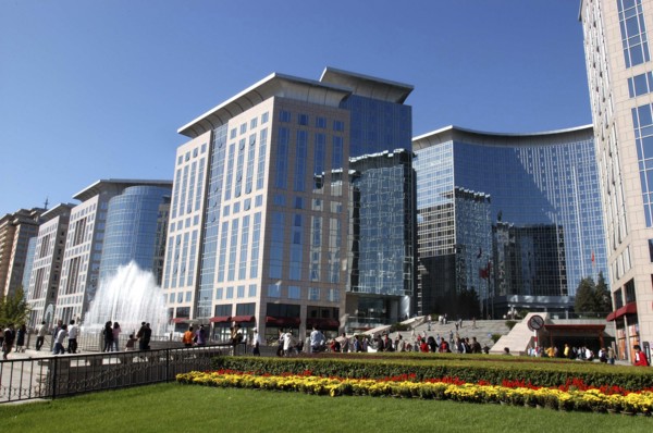 CHINA, Beijing, Modern city architecture with red and yellow flowerbeds in the foreground