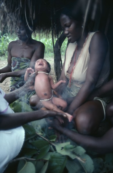SUDAN, People, Azande women and child during ritual purification of new born baby in smoke.