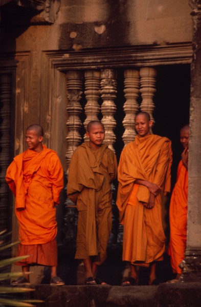 CAMBODIA, Siem Reap Province, Angkor Wat, Buddhist monks standing in front of window of upper level