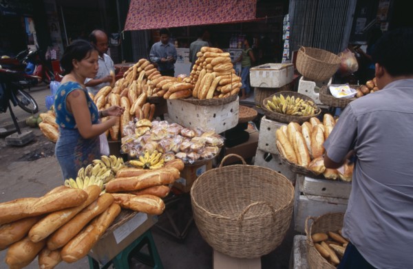 CAMBODIA, Siem Reap, Market stall selling bread and bananas with customers
