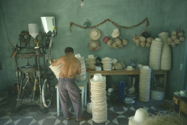 COLOMBIA, Narino Department, Sandona, Panama hat industry.  Male worker operating machinery with