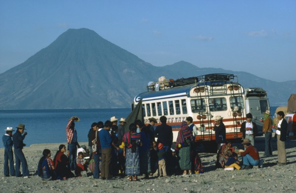 MEXICO, Transport, A group of passengers gathered around a bus with mountain scenery behind.
