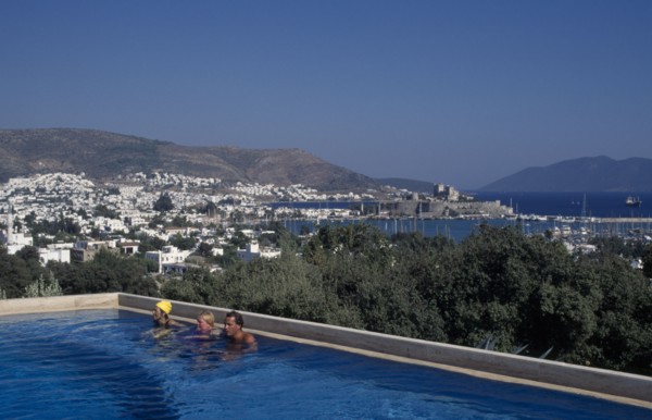 TURKEY, Aegean Region, Mugla, Bodrum.  People in swimming pool of Antik Theatre Hotel in foreground