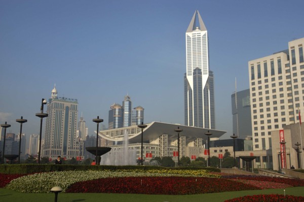 CHINA, Shanghai, Modern city skyline seen over formal garden in the foreground