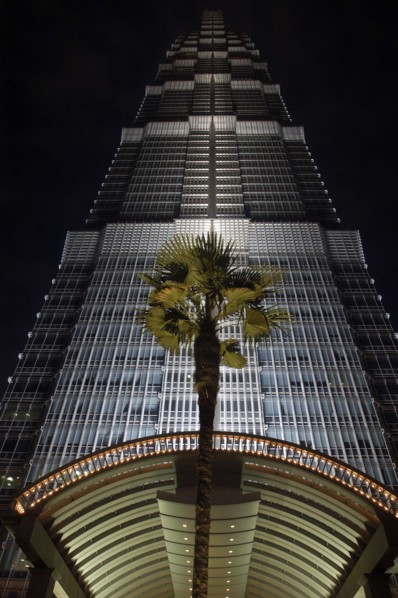 CHINA, Shanghai, Angled view looking up at the Hyatt Hotel skyscraper illuminated at dusk with