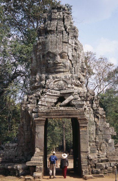 CAMBODIA, Siem Reap, Angkor, Ta Prohm monastic complex with tourists walking through the four faced
