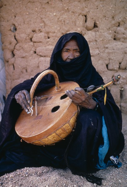 NIGER, Tribal Music, Tuareg woman playing an Imzad.  Traditional instrument consisting of a