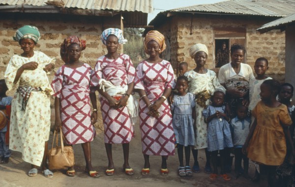 NIGERIA, Marriage, "Polygamy.  Wives of the same man, framed in window behind, wearing dresses made