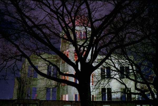 JAPAN, Honshu, Hiroshima, View of the A Bomb Dome illuminated at night seen through silhouetted