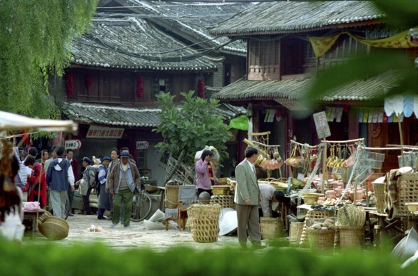 CHINA, Yunnan, Lijiang, Street scene with various market stalls selling household goods