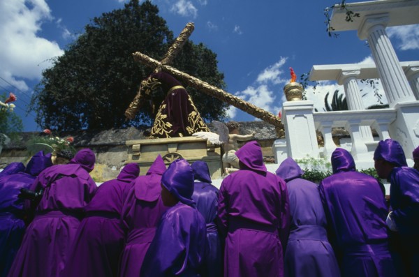 GUATEMALA, Antigua, Easter procession with man carrying wooden cross