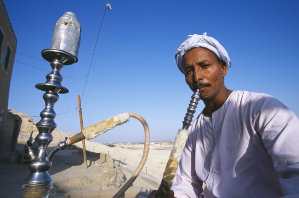 EGYPT, Dra Abul Naga, Man smoking sheesha water pipe.