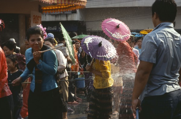 THAILAND, North, Chiang Mai , Girls with umbrellas being sprayed with water on the street during