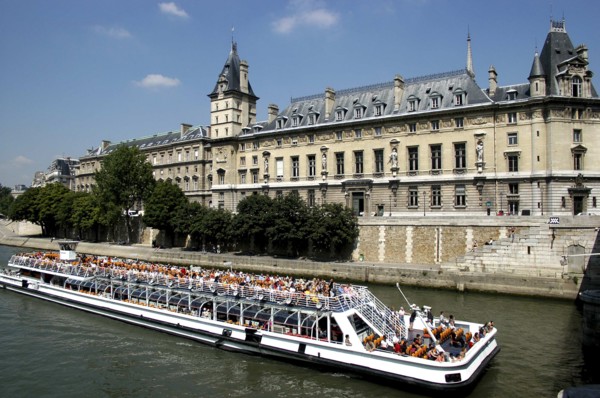 FRANCE, Ile de France, Paris, Open top tourist boat travelling down the River Seine