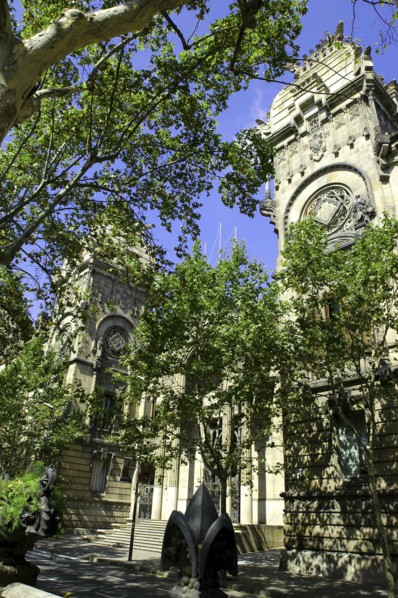 SPAIN, Catalonia, Barcelona, Angled view of the Barcelona Museum facade seen through trees