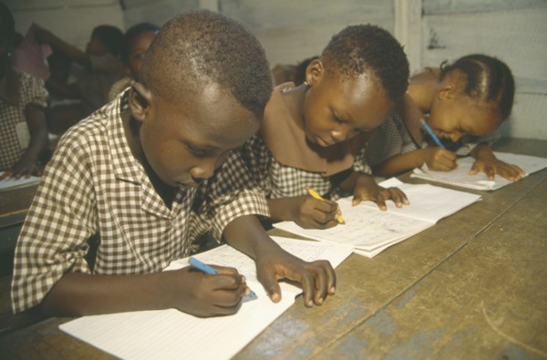GHANA, Accra, Primary school pupils writing at their desks.