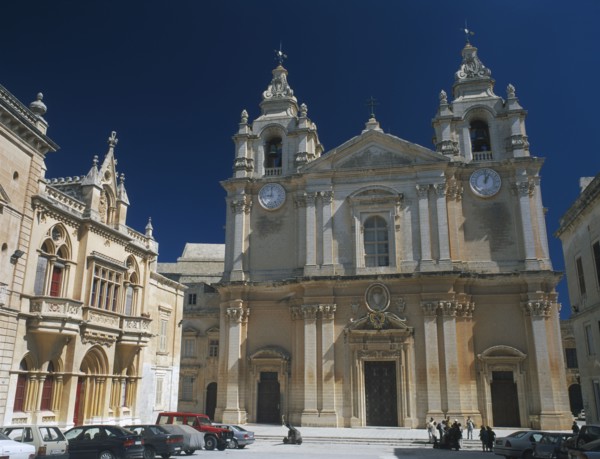 MALTA, Mdina, St Paul’s Square and Mdina Cathedral. View of exterior with cars parked in front.