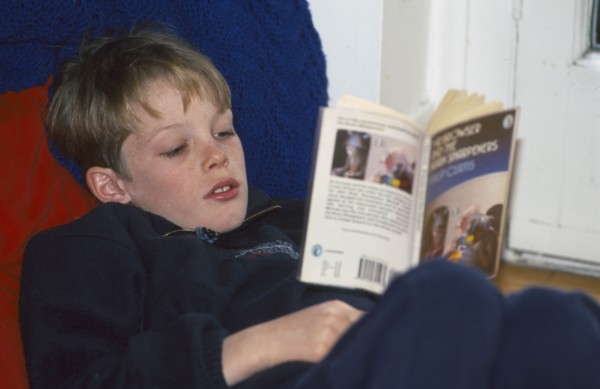EDUCATION, Literacy, Reading, Boy reading a paper back book