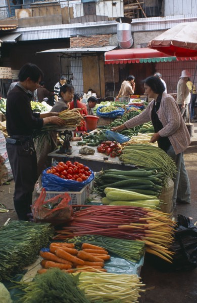 CHINA, Yunnan , Kunming, Covered food market with displays of fresh vegetables.