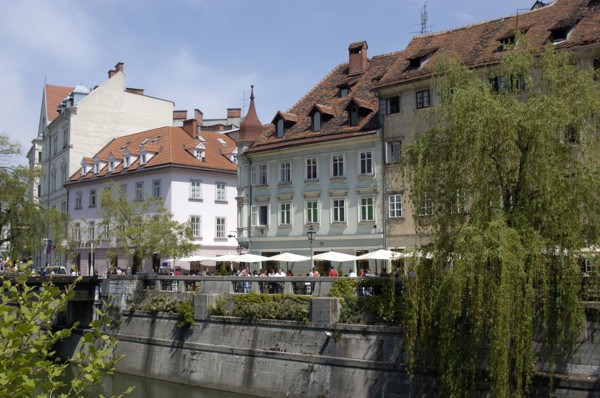 SLOVENIA, Ljubljana, River Ljubljanica. View along row of riverside cafes toward the old town