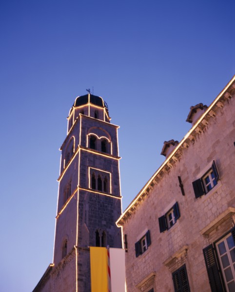 CROATIA, Dalmatia, Dubrovnik, Angled view looking up at the Francisan Monastery tower illuminated