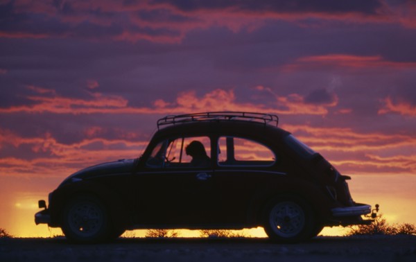 NAMIBIA, Transport, VW Beetle in silhouette against dramatic sunset sky.