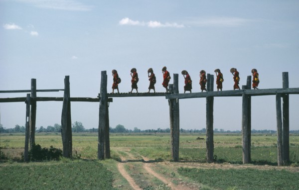 MYANMAR, Amarapura Bridge, Line of monks crossing two hundred and fifty year old bridge over flood