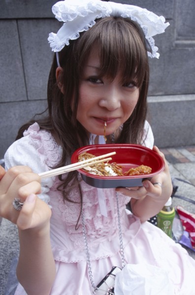 JAPAN, Honshu, Tokyo, Harajuku District. Portrait of young teenage girl eating noodles