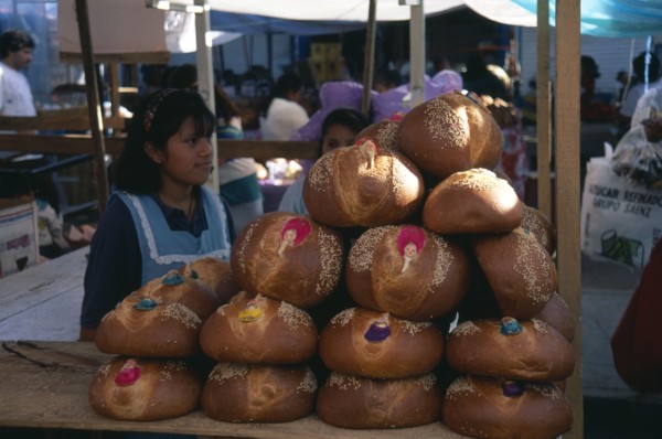 MEXICO, Oaxaca, Girls selling decorated bread for Day of the Dead.