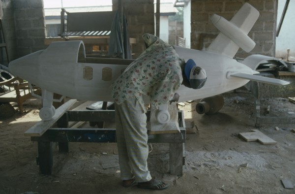 GHANA, Teshie, Kane Kwei brothers workshop.  Man painting and gluing together the wooden sections