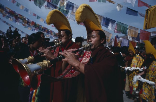 20061197 NEPAL  Bodhanath Monks of the Gelug pa sect proceed a photograph of the Dalai Lama playing shenai horns.