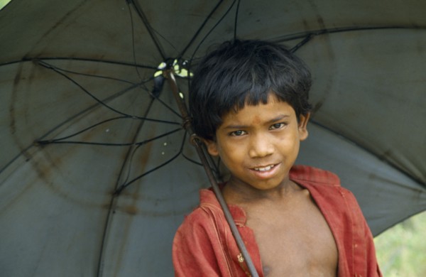 NEPAL, Terai Region, Children, Portrait of schoolboy with an umbrella.