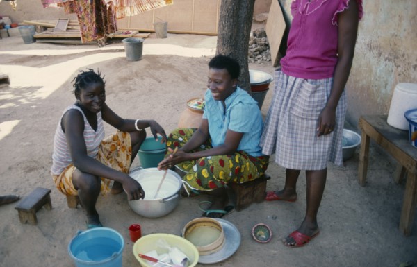 BURKINA FASO, Ouagadougou, Girls stirring milk.