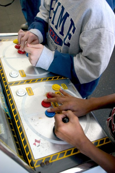 USA, Minnesota, St Paul, Hands of players age 10 intently playing a video game during a Youth