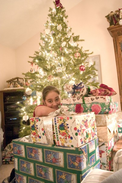 USA, Minnesota, Brooklyn Center, Girl aged 12 happily surronded by piles of Christmas presents and