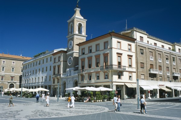 ITALY, Emilia-Romagna, Rimini, Town square with church and clock tower and cafes with outside
