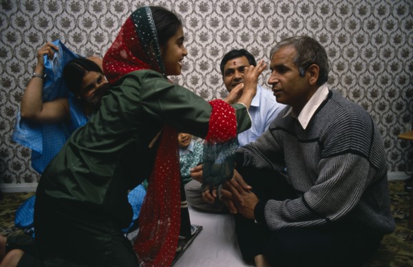 ENGLAND, Religion, Hindu, Daughter placing red mark on the forehead of her father during Hindu