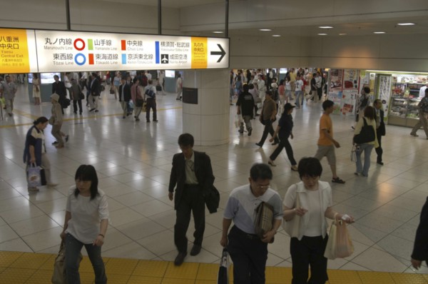 JAPAN, Tokyo , Tokyo station interior with crowds and bilingual color-coded signs above